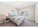 Bright bedroom featuring a striped bedspread, accent wall decor, and natural light from a window at 3037 Freeman Farm Way, Rolesville, NC 27571