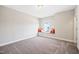 Empty bonus room featuring a window seat with orange pillows and soft carpeting at 3037 Freeman Farm Way, Rolesville, NC 27571