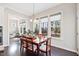 Cozy dining area with a wooden table, six chairs, and large windows with a view of the backyard at 3037 Freeman Farm Way, Rolesville, NC 27571