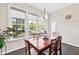 Sunny dining area with a dark wooden table, seating for six, and large windows overlooking the green backyard at 3037 Freeman Farm Way, Rolesville, NC 27571