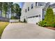 Spacious driveway leading to a two-car garage, with landscaping and exterior details visible on the home's side at 3037 Freeman Farm Way, Rolesville, NC 27571