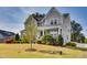 Beautifully landscaped front yard with a charming two-story home featuring a covered porch and gray siding at 3037 Freeman Farm Way, Rolesville, NC 27571