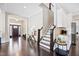Inviting foyer with dark wood floors, a staircase, and an open view into the entryway with a dark front door at 3037 Freeman Farm Way, Rolesville, NC 27571
