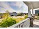 Street view from a covered front porch with white railing and stone columns, showcasing the neighborhood at 3037 Freeman Farm Way, Rolesville, NC 27571