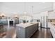 Modern kitchen featuring a large island that flows seamlessly into the dining and living areas at 3037 Freeman Farm Way, Rolesville, NC 27571