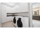 Functional laundry room featuring modern appliances and ample storage space with white cabinets at 3037 Freeman Farm Way, Rolesville, NC 27571