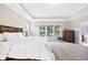 Bright primary bedroom featuring a trey ceiling, large window, and wooden furniture at 3037 Freeman Farm Way, Rolesville, NC 27571