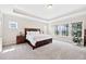 Sun-filled main bedroom with large windows, wood furniture, and a trey ceiling at 3037 Freeman Farm Way, Rolesville, NC 27571