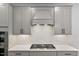 Modern kitchen features a stainless steel range hood, tiled backsplash, and sleek cabinetry at 33 Highpointe Dr, Pittsboro, NC 27312