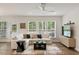 Spacious living room with ample windows, a ceiling fan, comfortable sofa, and stylish decor at 33 Highpointe Dr, Pittsboro, NC 27312