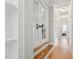 Hallway with hardwood floors, built-in shelving, French doors, and natural light at 3545 Donlin Dr, Wake Forest, NC 27587