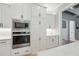 Close up view of kitchen wall oven and white cabinets, adjacent to open pantry at 3545 Donlin Dr, Wake Forest, NC 27587