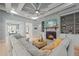 Bright living room featuring a fireplace, built-in shelving, tray ceilings, and a comfortable sectional sofa at 3545 Donlin Dr, Wake Forest, NC 27587
