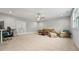 Neutral living room offers plush carpet, ceiling fan, and access to french doors at 3545 Donlin Dr, Wake Forest, NC 27587