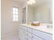 Bathroom with double vanity featuring white cabinets, quartz countertop and gold fixtures at 3608 Burwell Rollins Cir, Raleigh, NC 27612