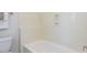 Bathroom with white tub and shower featuring molded shelving for storage at 3608 Burwell Rollins Cir, Raleigh, NC 27612