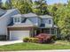 Charming two-story home with a well-manicured lawn, attached garage, brick accents, and mature trees at 3608 Burwell Rollins Cir, Raleigh, NC 27612