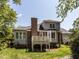 The exterior of the house featuring a brick chimney, deck and lush landscaping at 3608 Burwell Rollins Cir, Raleigh, NC 27612