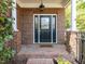 Elegant front door with glass panels, brick surround, and 'Home Sweet Home' welcome mat on a brick porch at 3608 Burwell Rollins Cir, Raleigh, NC 27612