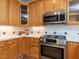 Close up view of the kitchen featuring stainless steel appliances, wood cabinets and modern design at 3608 Burwell Rollins Cir, Raleigh, NC 27612