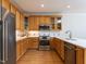 Well-lit kitchen with stainless steel appliances, under cabinet lighting, wooden cabinets, and wood floors at 3608 Burwell Rollins Cir, Raleigh, NC 27612