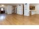 Open-concept living room with hardwood floors flowing into the kitchen area, adjacent to an entryway and staircase at 3608 Burwell Rollins Cir, Raleigh, NC 27612