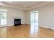 Bright living room with hardwood floors, a fireplace, French doors to a sunroom, and modern lighting at 3608 Burwell Rollins Cir, Raleigh, NC 27612