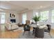Bright living room featuring hardwood floors, a fireplace, large windows, a dining area, and neutral decor at 3608 Burwell Rollins Cir, Raleigh, NC 27612