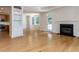 Open living area with hardwood floors, built-in shelves, a fireplace, and a view into the kitchen at 3608 Burwell Rollins Cir, Raleigh, NC 27612