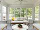 Bright sunroom with neutral decor, adorned with large windows, comfortable seating, and a round coffee table at 3608 Burwell Rollins Cir, Raleigh, NC 27612