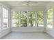 Sun-drenched sunroom featuring large windows, neutral walls, and ceramic tile flooring at 3608 Burwell Rollins Cir, Raleigh, NC 27612