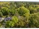 Aerial view of a beautiful home with dark shingles surrounded by lush greenery and mature trees at 3612 Darwin Rd, Durham, NC 27707