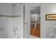 A clean bathroom features white tile, a tub, and a view into the hallway and staircase at 3612 Darwin Rd, Durham, NC 27707