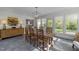 Bright dining room with rustic wooden table, modern chandelier, and large windows at 3612 Darwin Rd, Durham, NC 27707