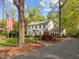 Charming two-story home with a brick walkway, mature trees, and an American flag in a well-manicured front yard at 3612 Darwin Rd, Durham, NC 27707