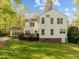 Rear exterior view of a two-story home showing a large manicured lawn, back deck and patio at 3612 Darwin Rd, Durham, NC 27707