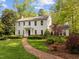 Stately two-story home boasting mature trees, a brick walkway, and beautifully maintained front yard landscaping at 3612 Darwin Rd, Durham, NC 27707