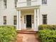 Inviting front entrance with white columns, dark door, brick walkway and manicured shrubbery at 3612 Darwin Rd, Durham, NC 27707