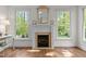 Living room boasts a fireplace, hardwood floors, and plentiful sunlight from the windows at 3612 Darwin Rd, Durham, NC 27707