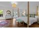 This primary bedroom has hardwood floors, a bench at the foot of the bed, and access to a private balcony at 3612 Darwin Rd, Durham, NC 27707