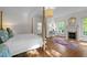 Bright main bedroom features hardwood floors, fireplace, a four-poster bed, and a view into the en-suite bathroom at 3612 Darwin Rd, Durham, NC 27707
