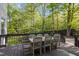 Outdoor deck with wooden dining table and seating, surrounded by lush trees at 3612 Darwin Rd, Durham, NC 27707