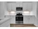 Close-up view of stainless steel oven and microwave, complemented by white cabinets and subway tile backsplash at 3667 Durwood Ln, Raleigh, NC 27604