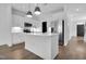 A modern white kitchen with a stainless steel refrigerator and pendant lighting provides a bright cooking space at 3667 Durwood Ln, Raleigh, NC 27604