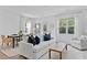 Cozy living room with a white sofa, dining table, and large windows providing natural light at 3667 Durwood Ln, Raleigh, NC 27604