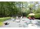 Backyard features a gravel patio with outdoor seating, a fire pit, and mature trees at 38 Maple Cir, Pittsboro, NC 27312