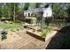 Backyard features raised garden beds, windmill, ramp access to house, and patio area at 38 Maple Cir, Pittsboro, NC 27312