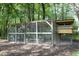 Well-maintained chicken coop with shaded area and secure enclosure at 38 Maple Cir, Pittsboro, NC 27312