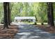 Idyllic exterior view of a home with a long driveway, lush trees, and a well-maintained lawn at 38 Maple Cir, Pittsboro, NC 27312