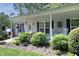 Inviting home featuring a covered front porch, trimmed landscaping, and a charming entrance with decorative accents at 38 Maple Cir, Pittsboro, NC 27312